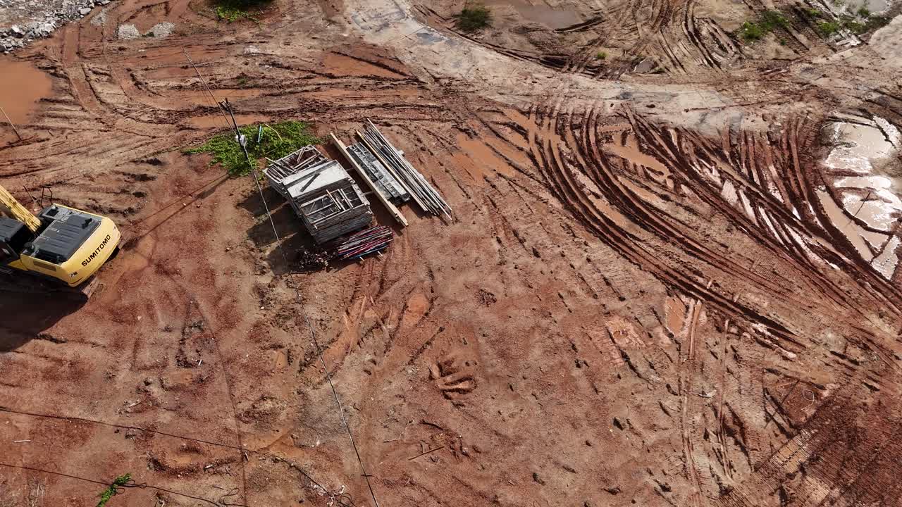 Aerial View of Construction Site with Excavator and Construction Materials