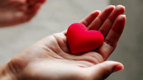 un corazón rojo en la mano