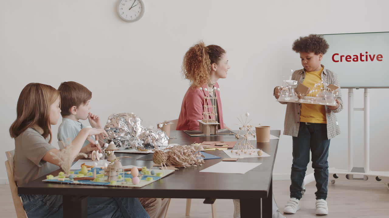 Boy Presenting Crafted Model to Class