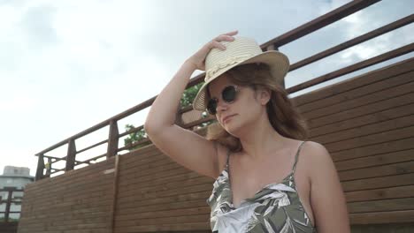 happy young latin american female white enjoys the beach on her vacations in brazil. he has a hat and sunglasses.