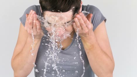 Woman-throwing-water-on-her-face-in-slow-motion