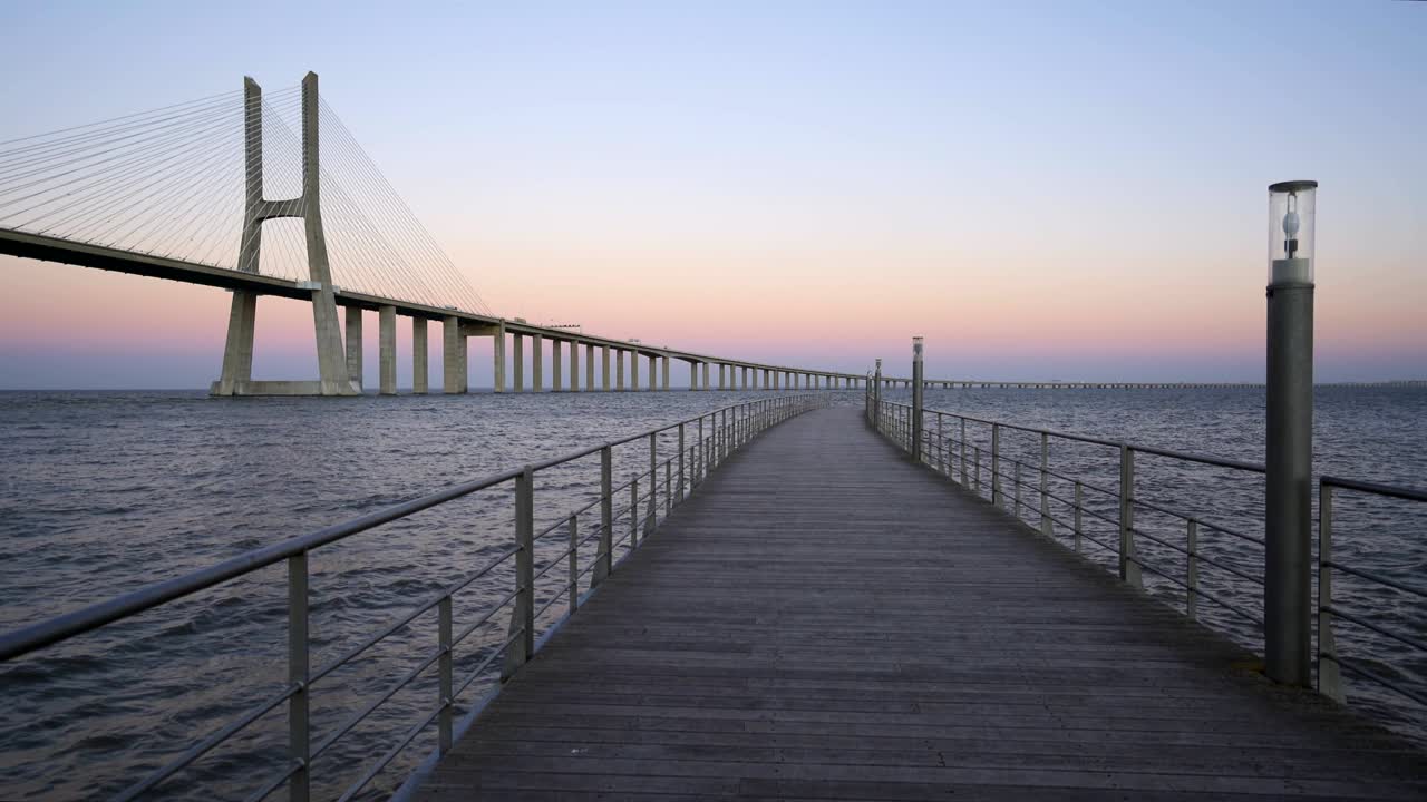 puente vasco da gama vista desde un muelle al atardecer