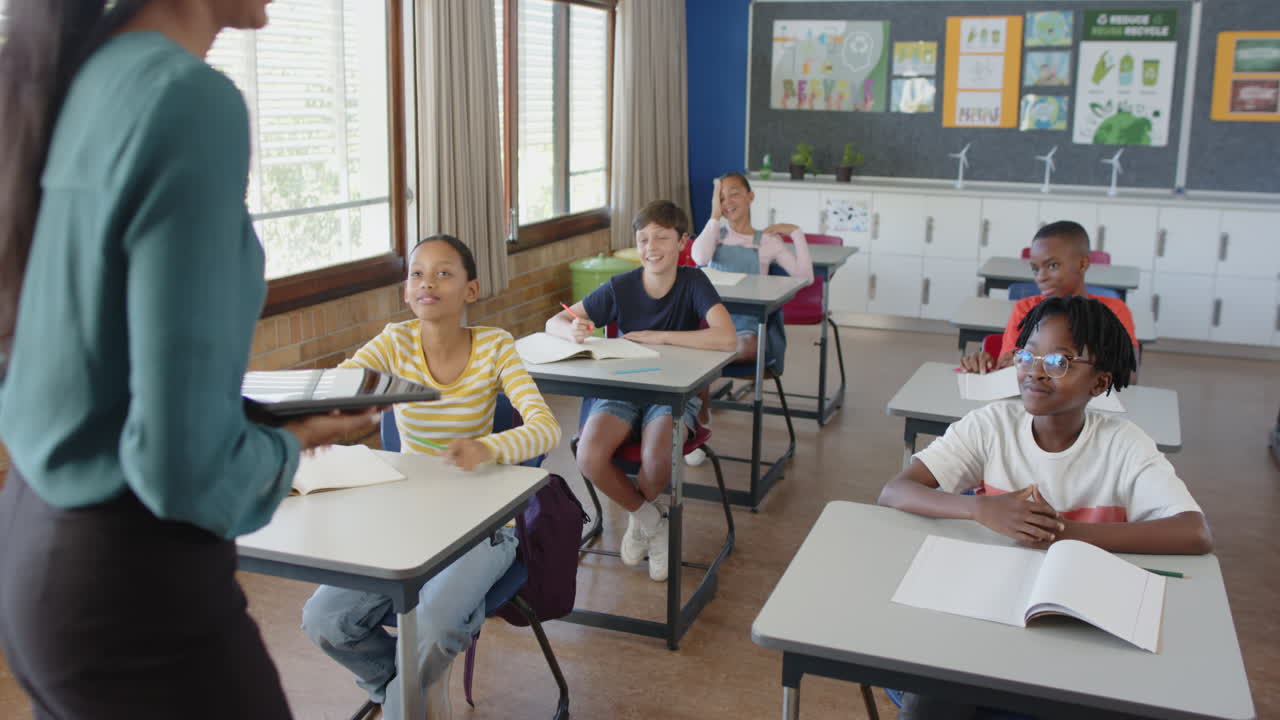In school classroom, students sitting at desks, listening to teacher