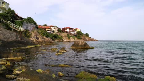 Low-aerial-flight-over-water-and-rocks-at-sozopol-bay-black-sea-coast-Bulgaria