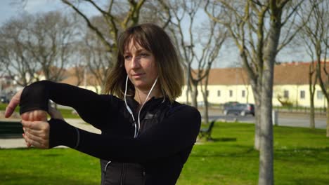 Schöne-Konzentrierte-Sportlerin,-Die-Im-Park-Die-Hände-Ausstreckt