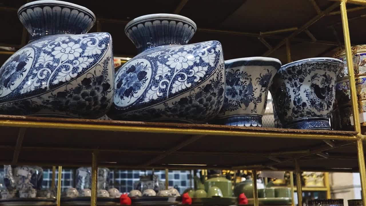 A collection of intricately patterned blue and white ceramic vases arranged on shelves.