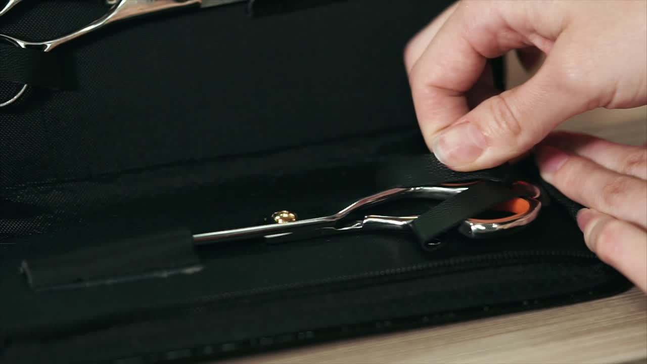 Putting away hair scissors in a black case