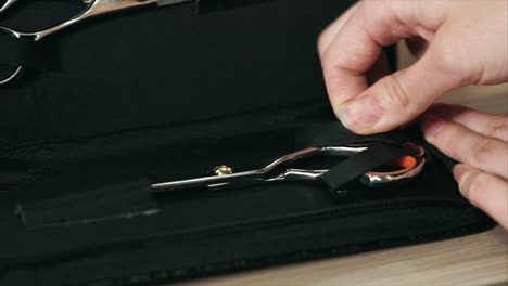 putting away hair scissors in a black case
