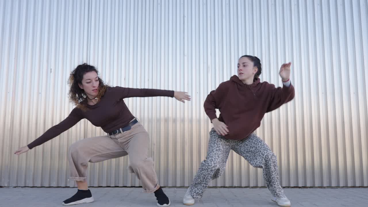 Female dancers performing choreography in urban setting