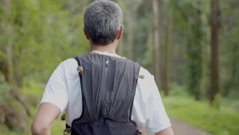 man running on trail in forest