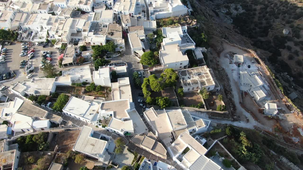 vista de drones en grecia vista superior sobre una ciudad de casas blancas griegas con techos blancos en una montaña marrón