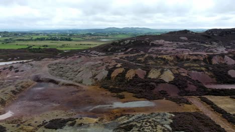 Parys-mountain-abandoned-historic-copper-mine-purple-mining-industry-landscape-aerial-pan-right-view