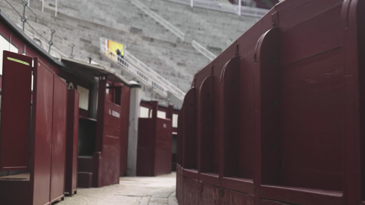 Beautiful slow motion zoom in shot from inside and the benches of the bullring in Las Ventas, Madrid without people during a summer day.