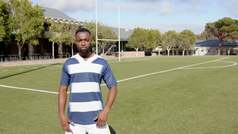 standing on rugby field, african american man in sportswear posing for fitness shoot, copy space