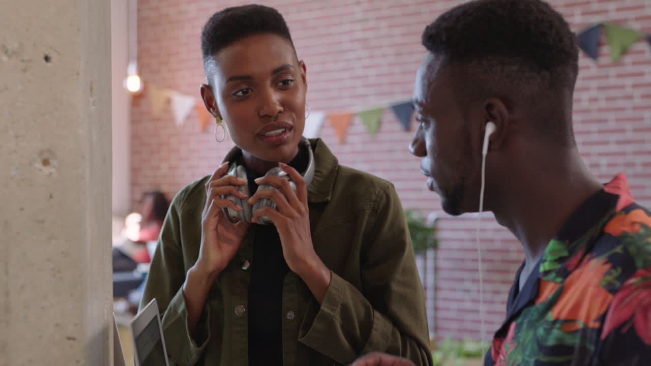 young african american business people brainstorming working together sharing ideas wearing headphones listening to music in trendy office workplace