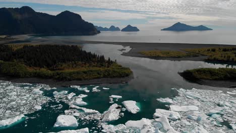 Icebergs-Float-On-The-Surface-Of-Calm-Lake-Near-National-Forest-Park-During-Autumn-Under-Cloudy-Sky-In-Alaska,-USA