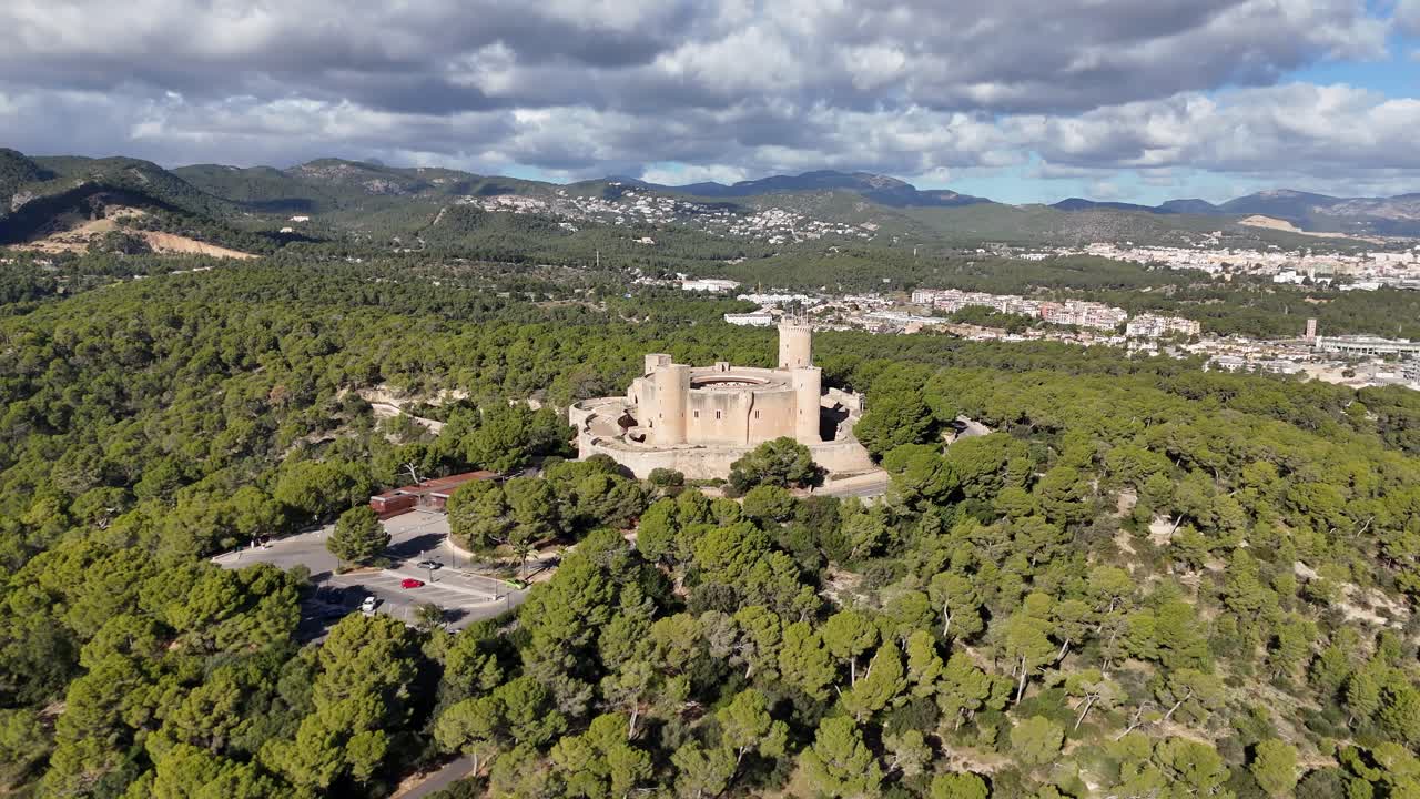 Vista aérea do Castelo de Bellver na cidade de Palma, rodeado por uma paisagem montanhosa verdejante na Ilha de Maiorca