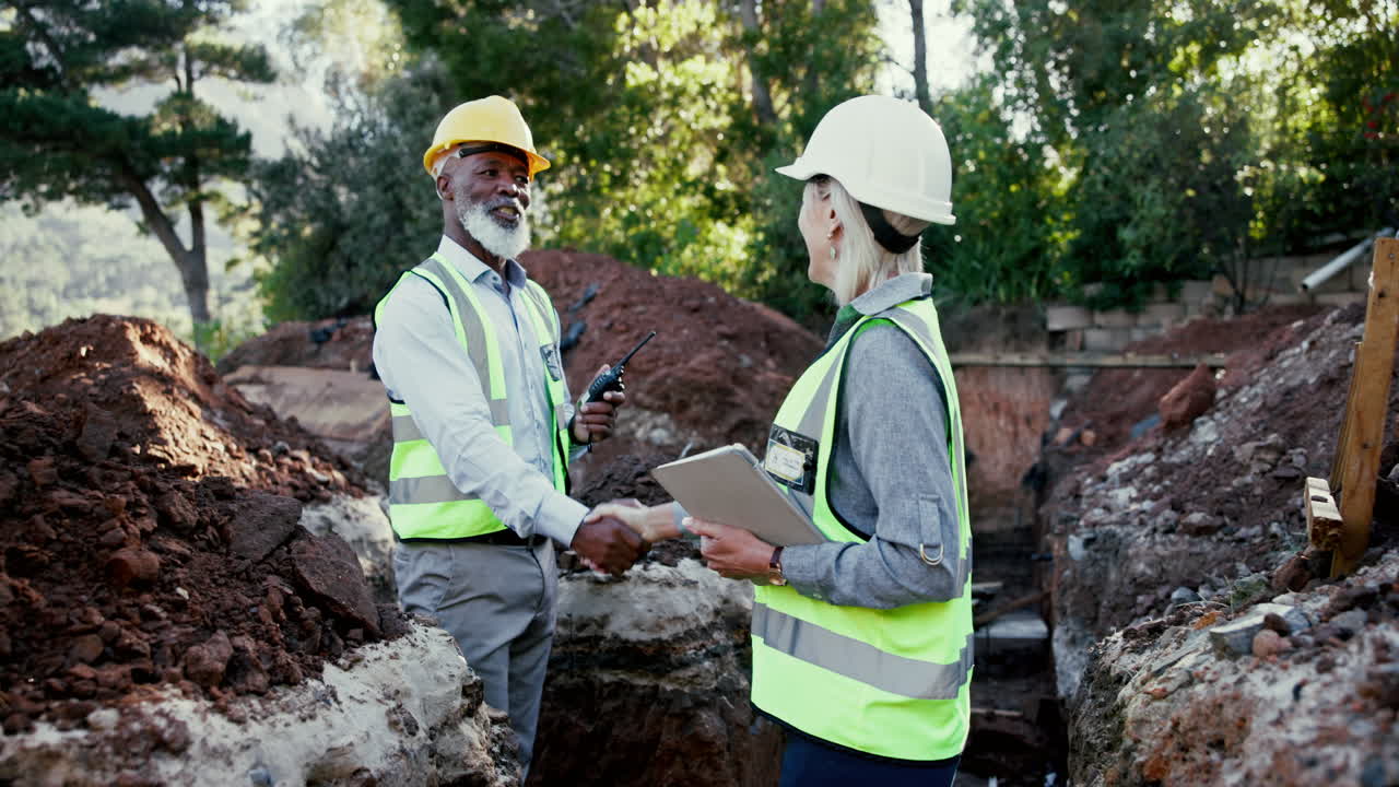 Construction workers shaking hands at a job site