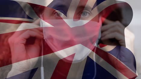 bandera británica ondeando contra una mujer con una máscara facial