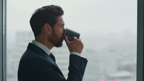 smiling ceo drinking tea looking office window feeling success close up.