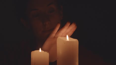 persona frente a las velas en la oscuridad