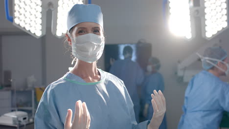 portrait of caucasian female surgeon wearing surgical gown in operating theatre, slow motion