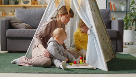 mom and little children playing in teepee