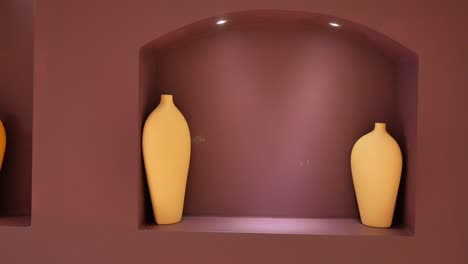 two vases on a wall shelf