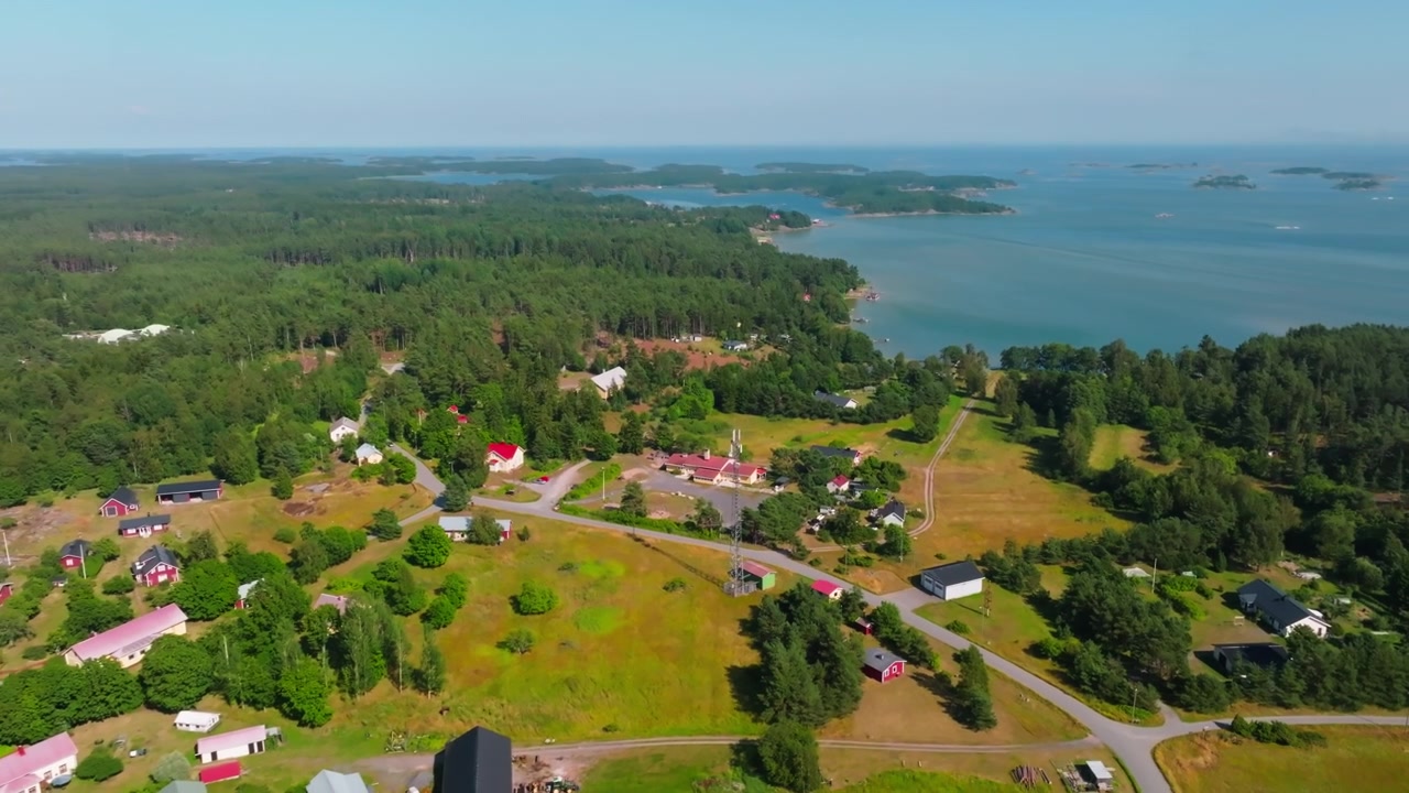 Pyörivä ilmakuva Hittisten saaren kylän yllä, kesäpäivä Suomessa