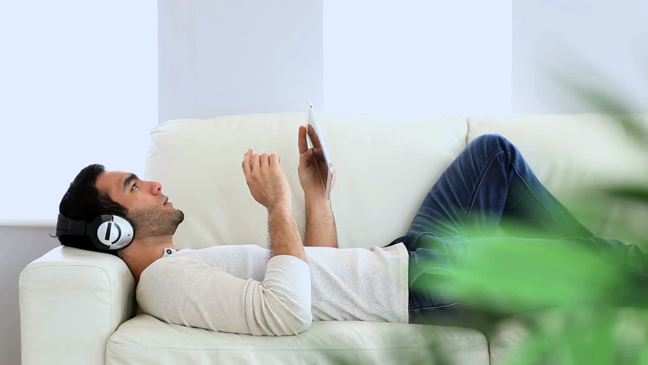 태블릿으로 음악을 듣고 있는 남자