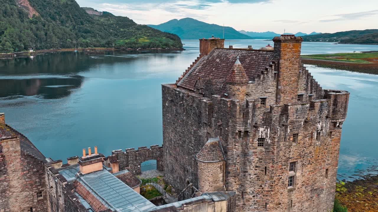 Scenic views of a historic castle surrounded by water and mountains