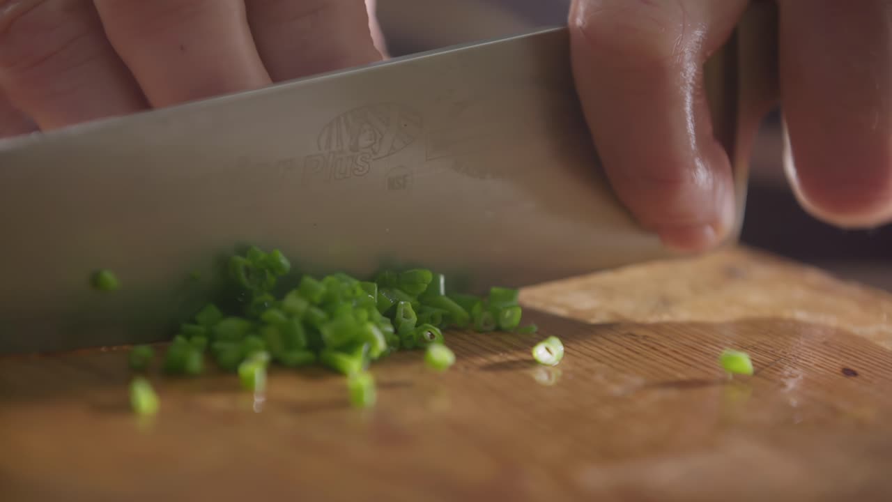 Chopping Fresh Green Onions on Wooden Cutting Board