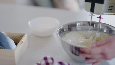 mixing milk ingredients eggs and flour in metal bowl