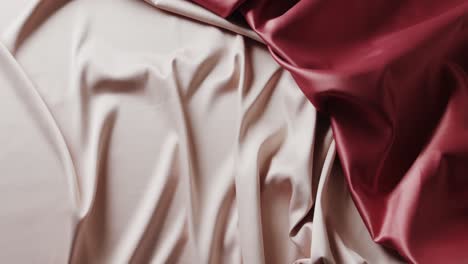 Close-up-of-white-and-red-shiny-silk-clothes-in-slow-motion-with-copy-space