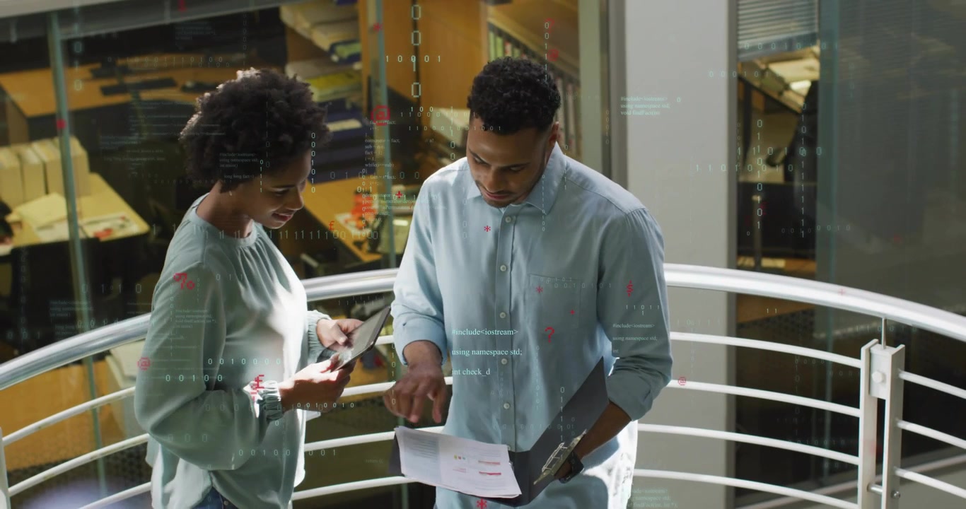 Man opening binder and reviewing tech charts with colleague using tablet diagrams