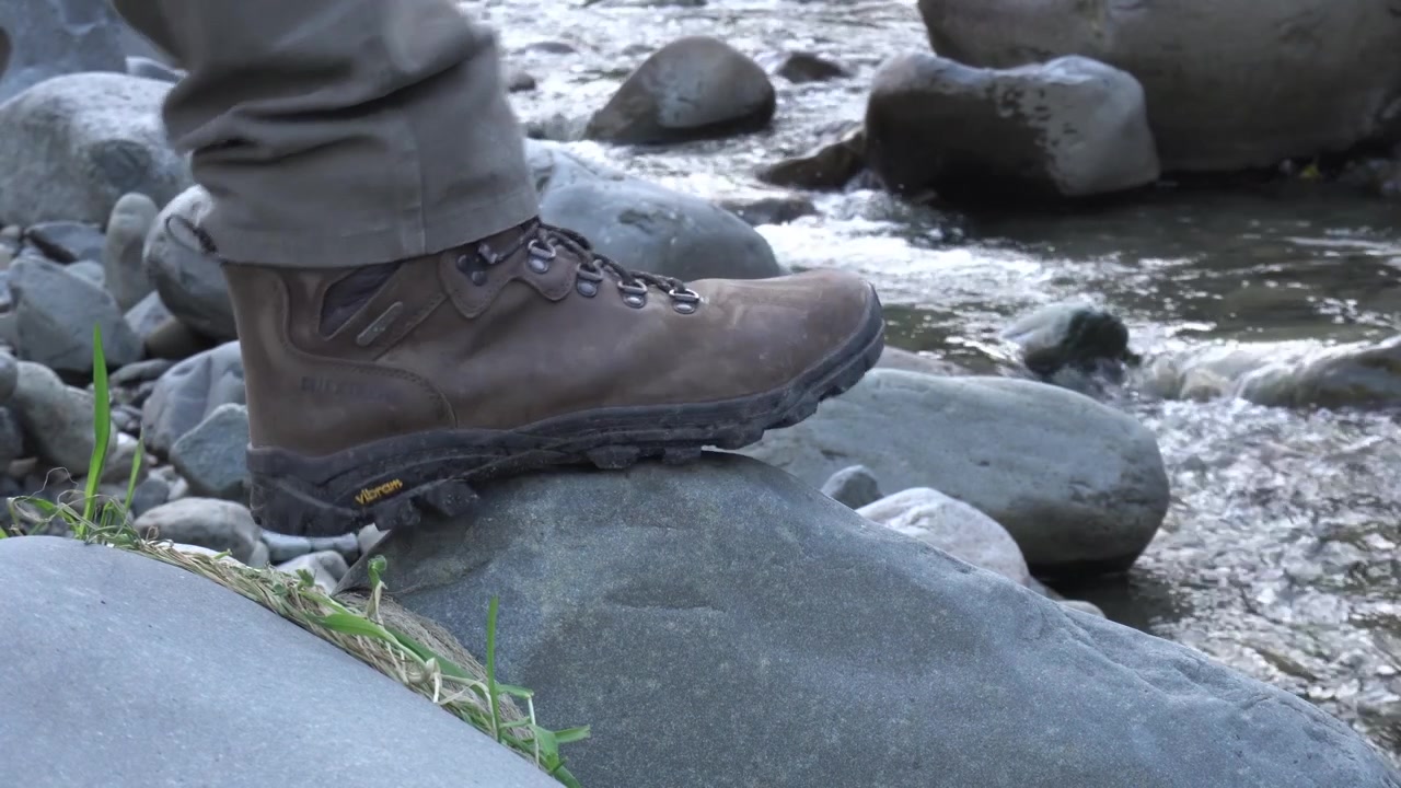 Botas de Caminhante Pisam em Rocha à Beira do Rio.