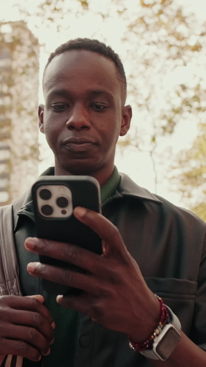 Giovane uomo di colore che usa lo smartphone all'aperto in città