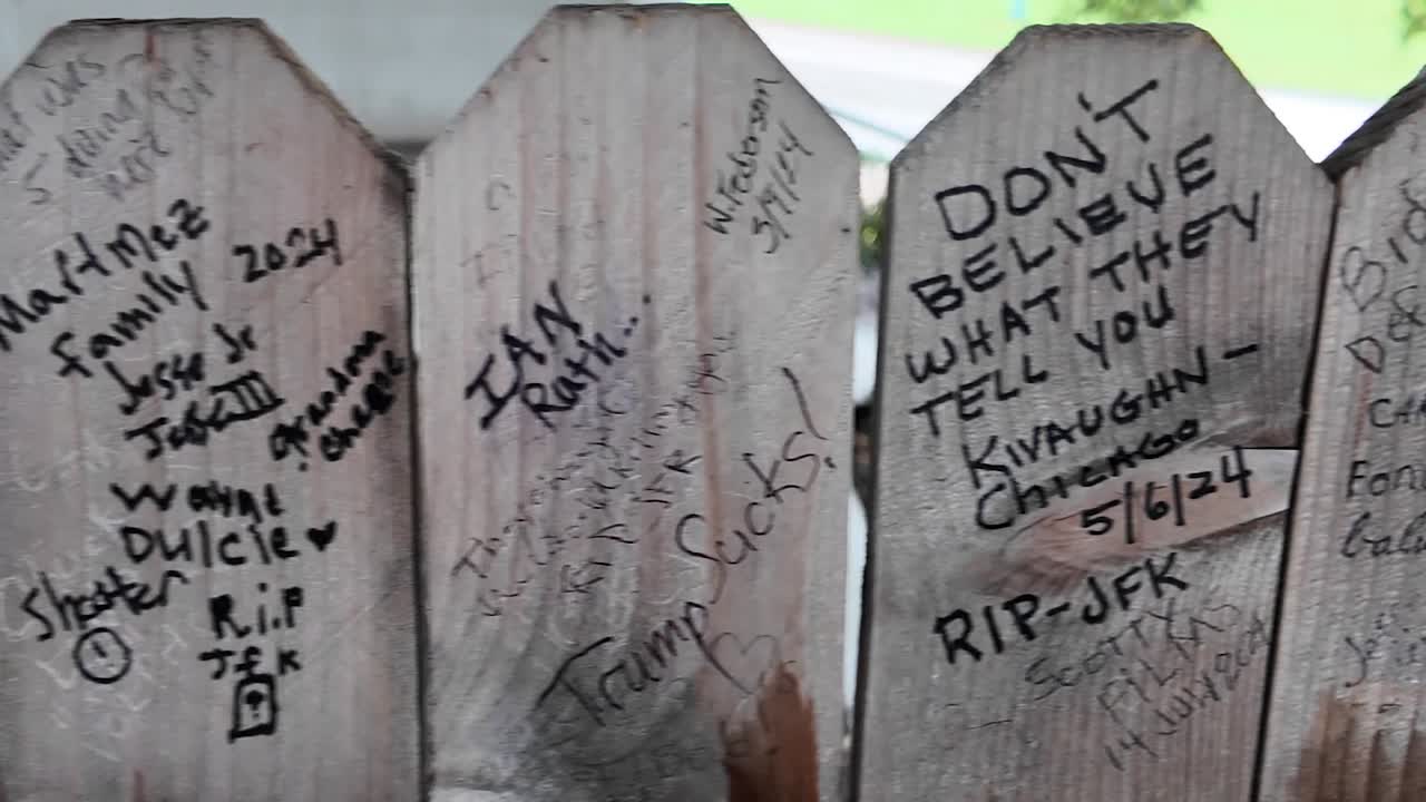 People leave grafitti messages on grassy knoll fence