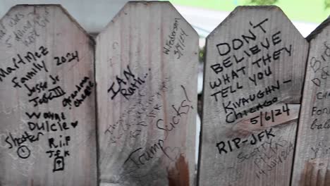 people leave grafitti messages on grassy knoll fence