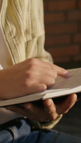 closeup of person reading a book outdoors