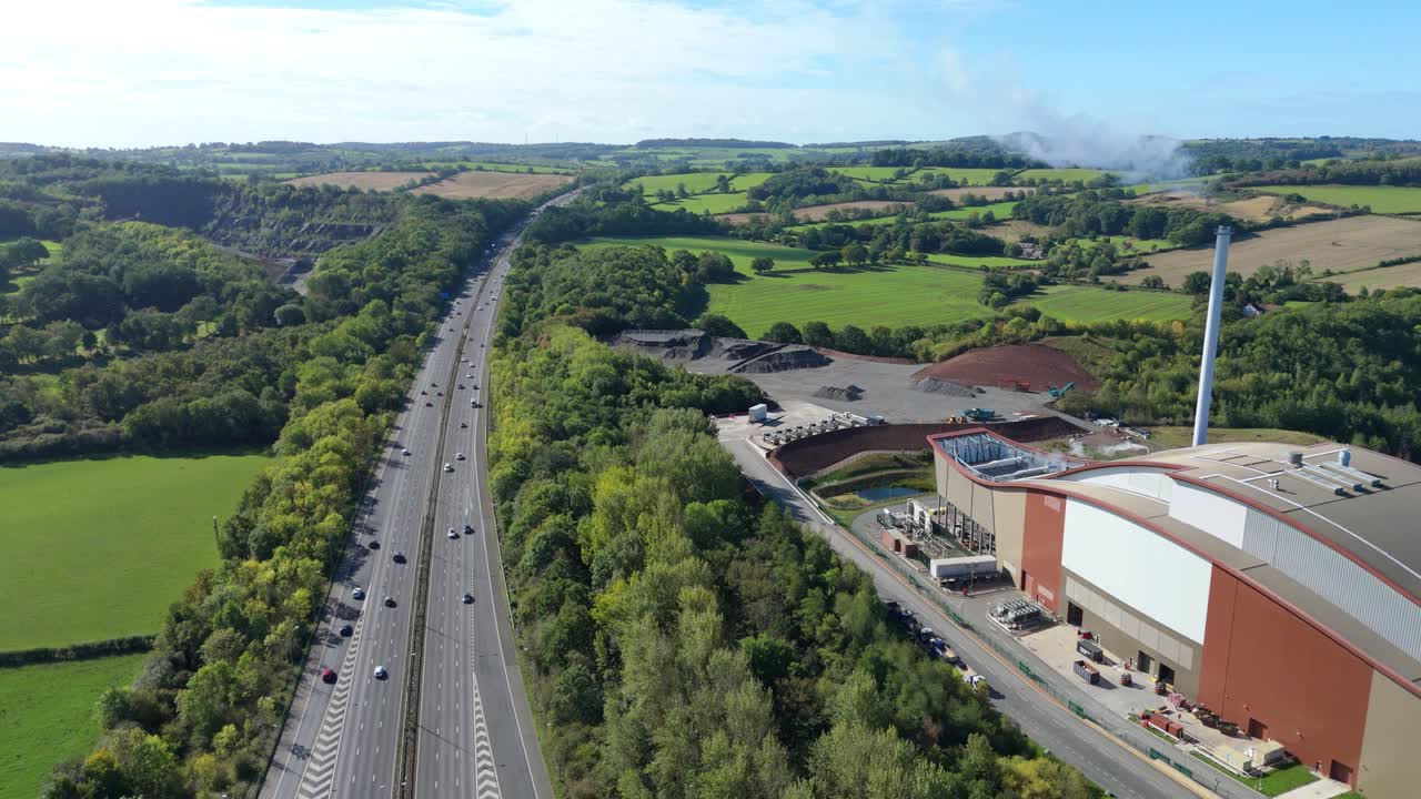 Drone video of biomass power plant and highway traffic near Loughborough, UK, showing chimney and pellet burning