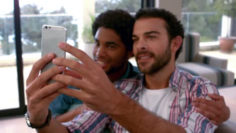 Gay-couple-relaxing-on-the-couch-taking-selfie