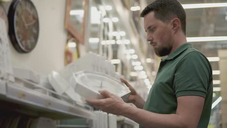hombre comprando un reloj de pared en una tienda de decoración para el hogar