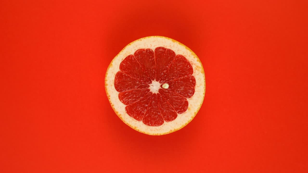 Pompelmo isolato su sfondo rosso, ruota