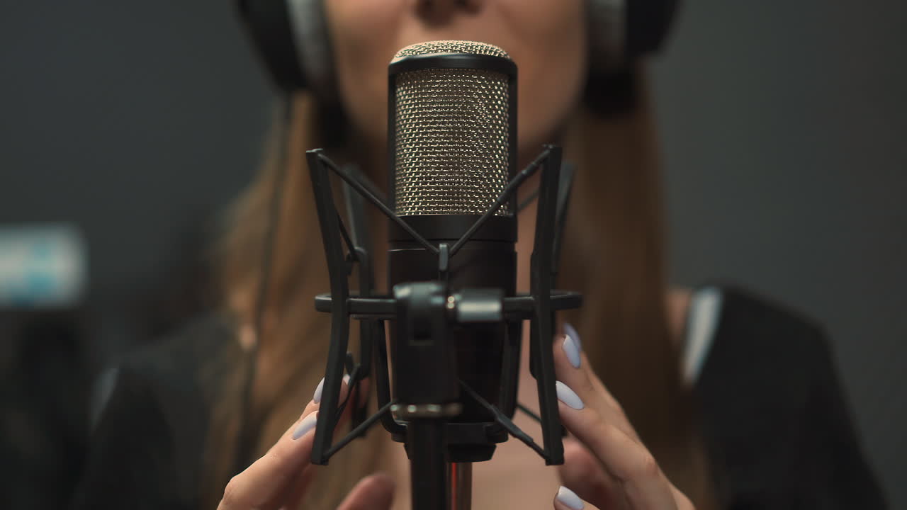 mujer talentosa graba una nueva canción en el estudio enfoque en el micrófono