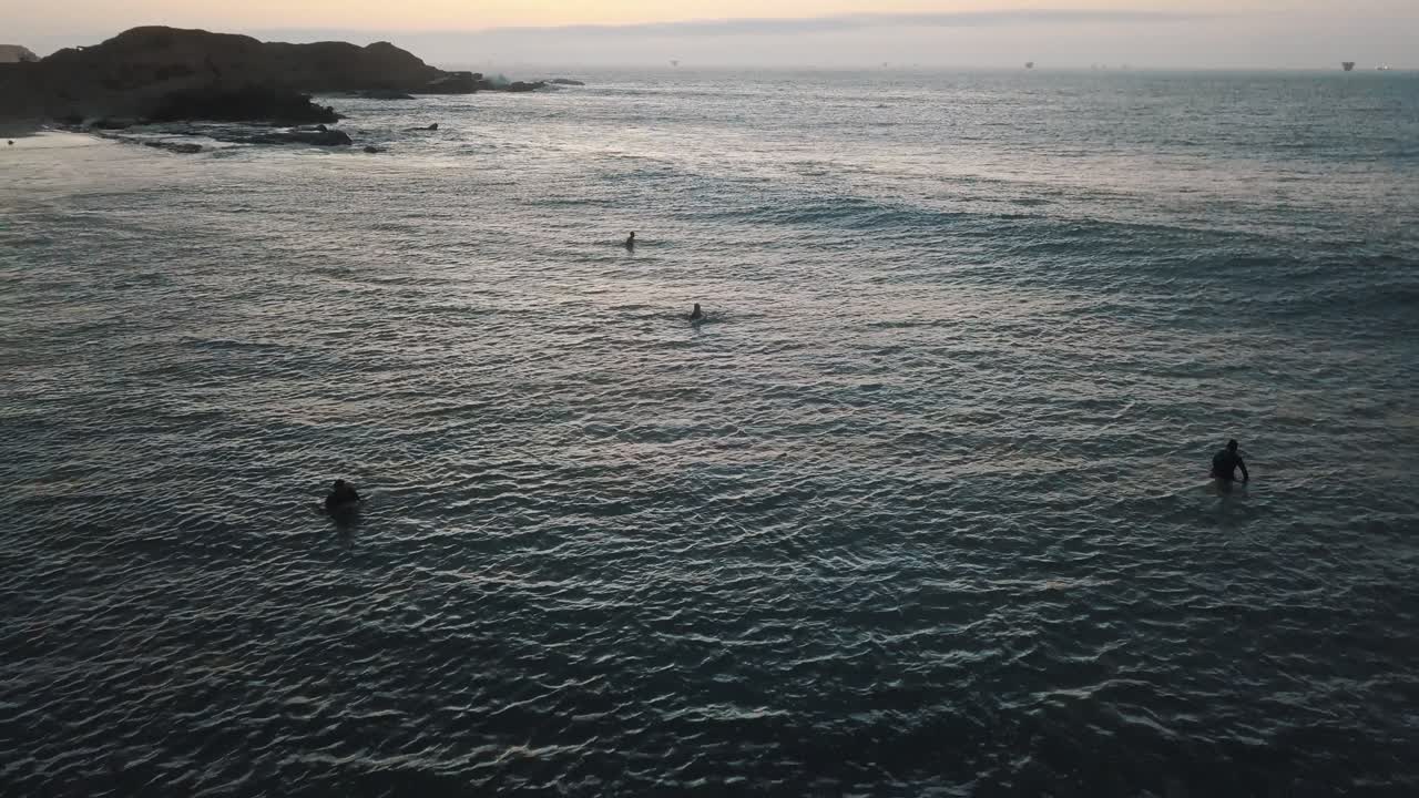 Rilassante veduta aerea con drone dell'oceano con una tavola da surf e surfisti in attesa in Sud America
