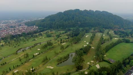 Aerial-view-on-golf-course-at-foothill-of-Tidar-hill-in-Magelang,-Java-Indonesia
