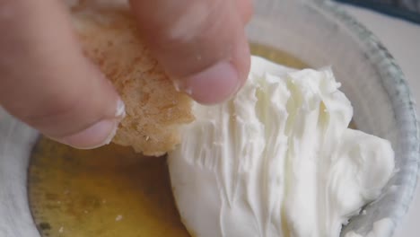 bread dipping into cream and honey