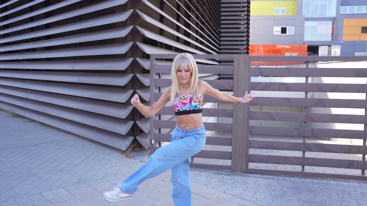A young woman dances gracefully outdoors displaying dynamic and energetic movements