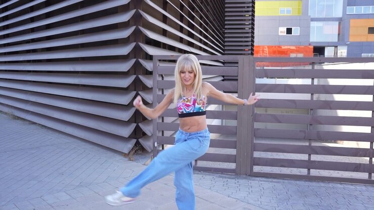 A young woman dances gracefully outdoors displaying dynamic and energetic movements